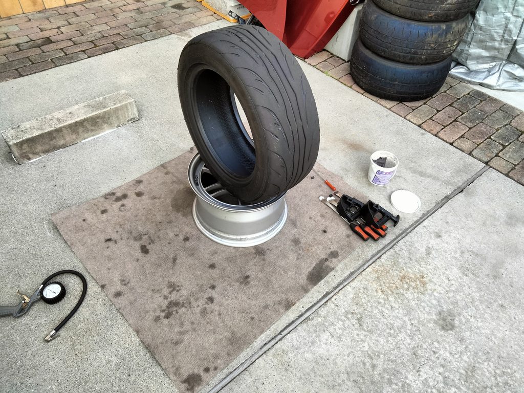 タイヤ手組みに使うタイヤレバーとビードヘルパー、ビードクリーム、エアゲージを並べた工具一式