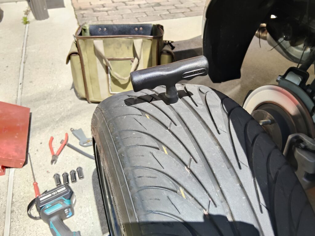 スクリューリーマーをパンク穴に押し込んで穴を拡大する作業