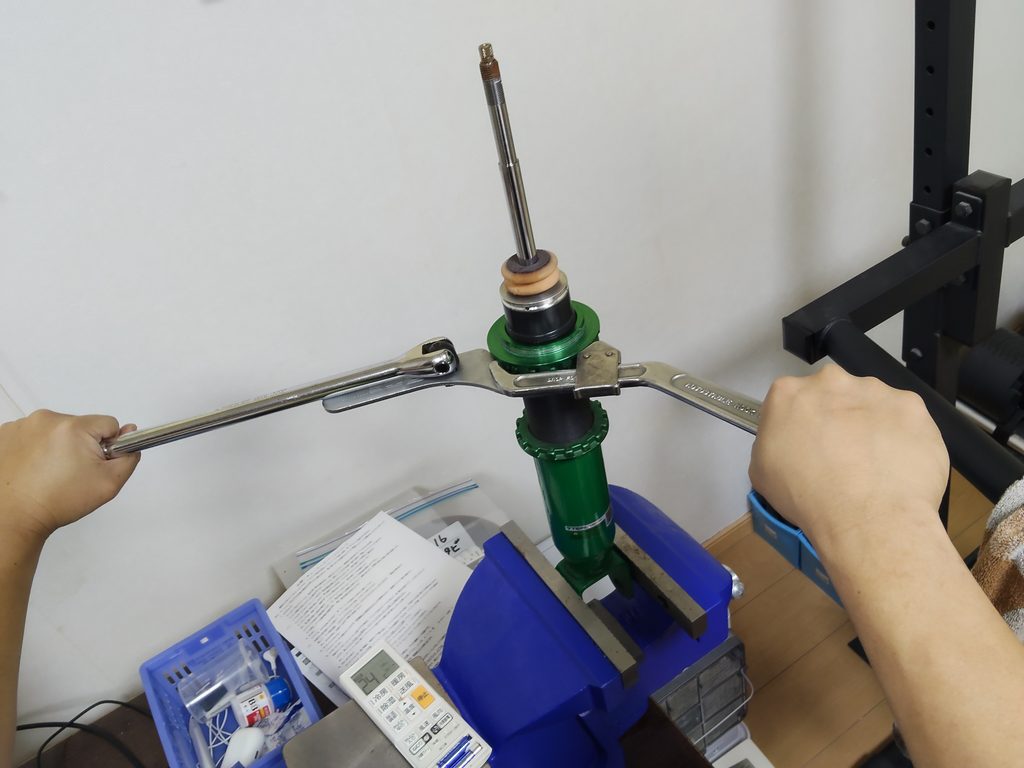 ベンチバイスで車高調を固定してロックナットを緩める作業